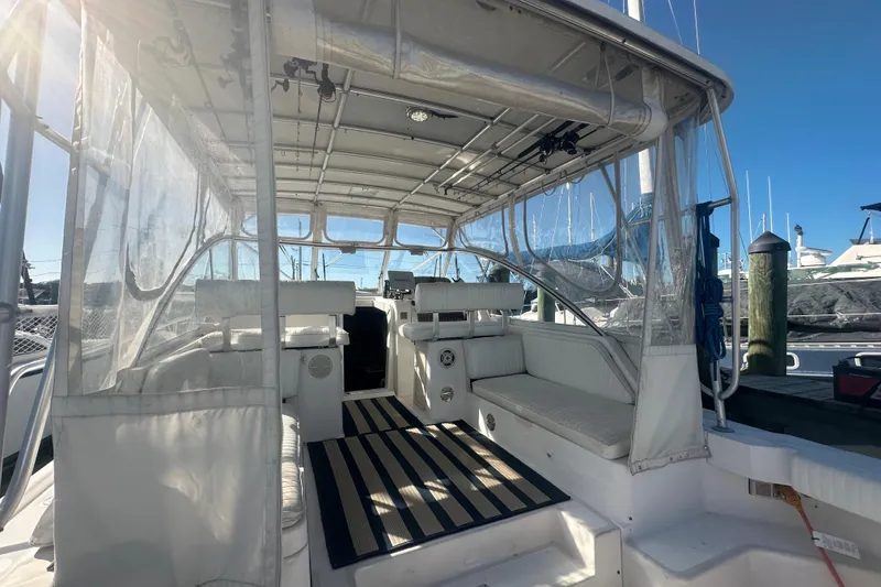 Slide: The Image of 2002 Mainship Pilot 34 boat interior with seating and clear canopy in marina. - 4