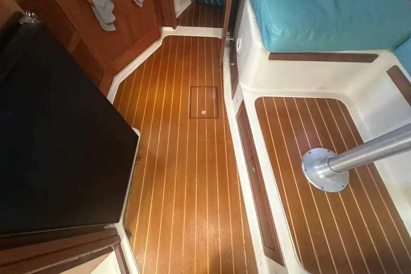 Slide: The Image of 2002 Mainship Pilot 34 interior with wood flooring and teal seating. - 42