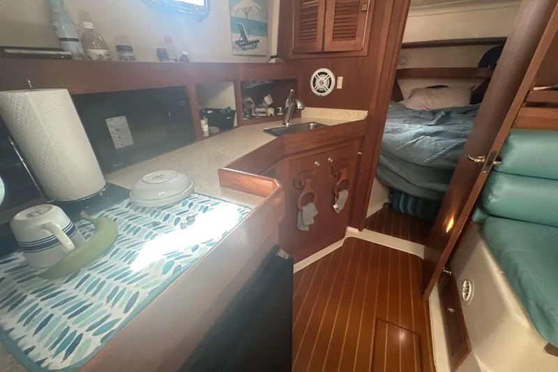 Slide: The Image of 2002 Mainship Pilot 34 interior with kitchenette and cozy sleeping area. - 47