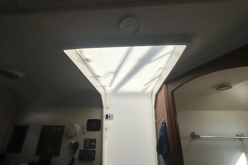 Slide: The Image of Interior of a 2002 Mainship Pilot 34 boat, featuring a skylight and control panels. - 48