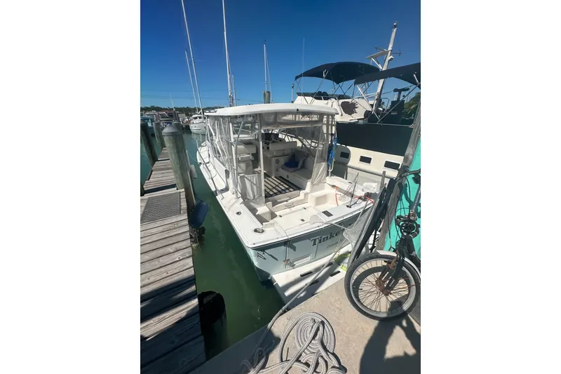 The Image of 2002 Mainship Pilot 34 docked at marina, sunny day, bicycle nearby. - 5