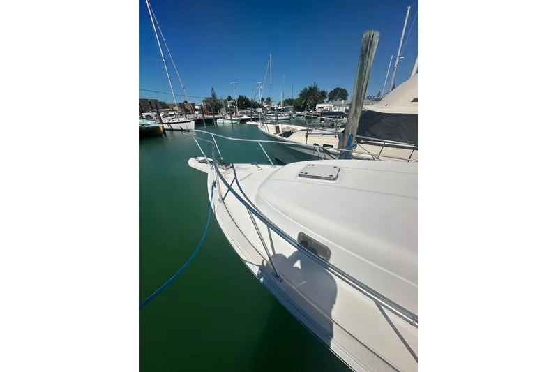 Slide: The Image of 2002 Mainship Pilot 34 docked in a marina under clear blue skies. - 8