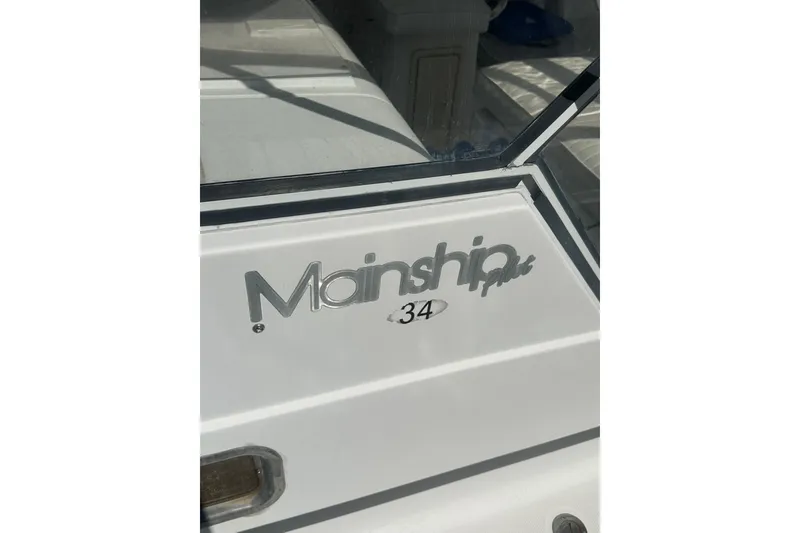 Slide: The Image of 2002 Mainship Pilot 34 boat logo on white surface. - 9