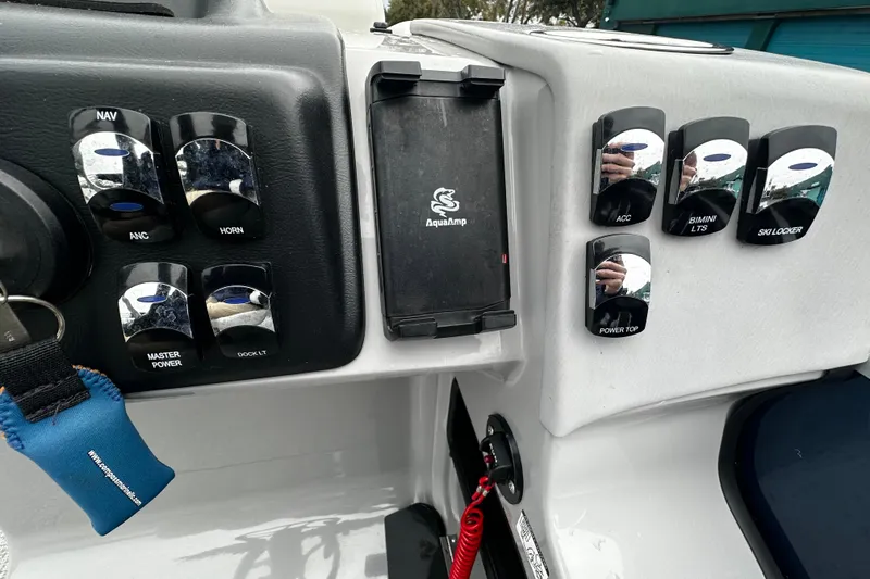 Slide: The Image of Control panel of 2025 Harris Sunliner 230 boat with various switches and key holder. - 6