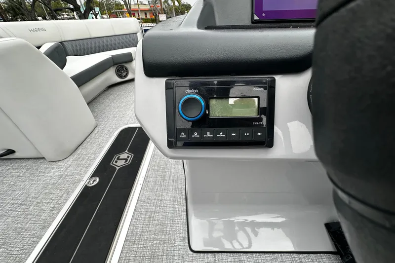 Slide: The Image of Interior of 2025 Harris Sunliner 230 boat featuring audio system and seating. - 7