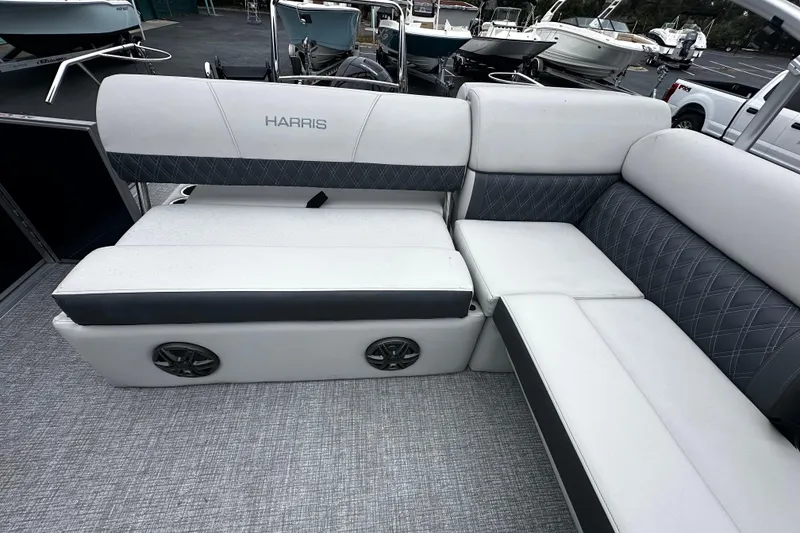 Slide: The Image of 2025 Harris Sunliner 230 boat interior with plush seating and integrated speakers. - 9