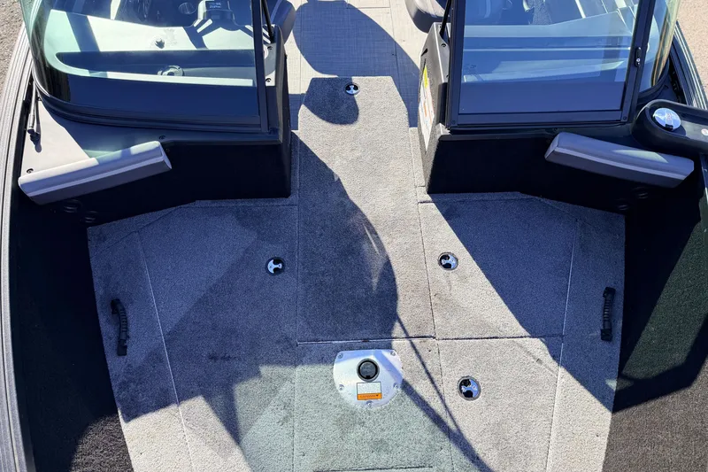 Slide: The Image of 2025 Alumacraft Competitor 185X Sport boat interior with carpeted deck and windshield. - 21