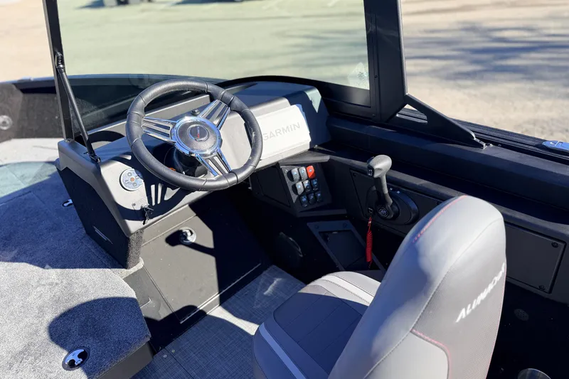 Slide: The Image of 2025 Alumacraft Competitor 185X Sport boat interior with steering wheel and Garmin navigation system. - 22