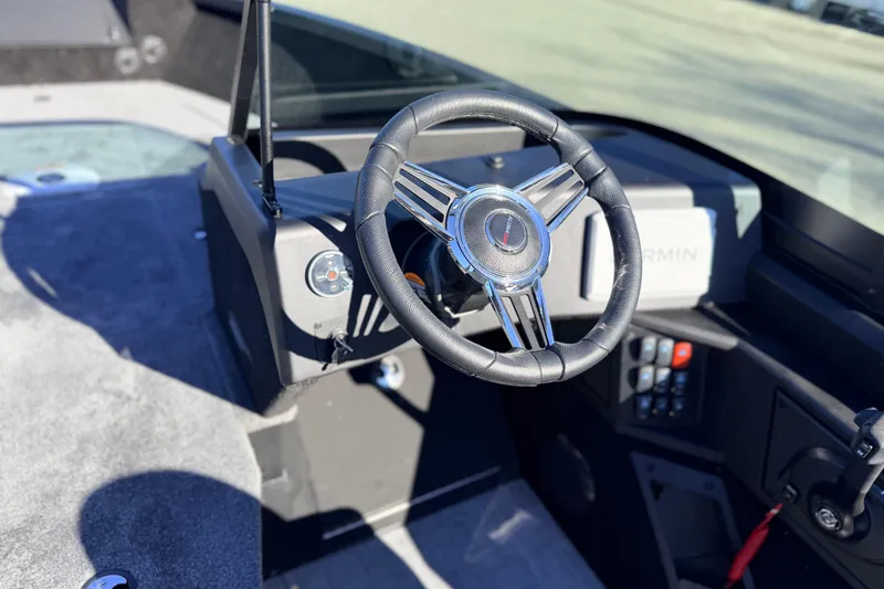 Slide: The Image of 2025 Alumacraft Competitor 185X Sport boat dashboard with steering wheel and controls. - 25