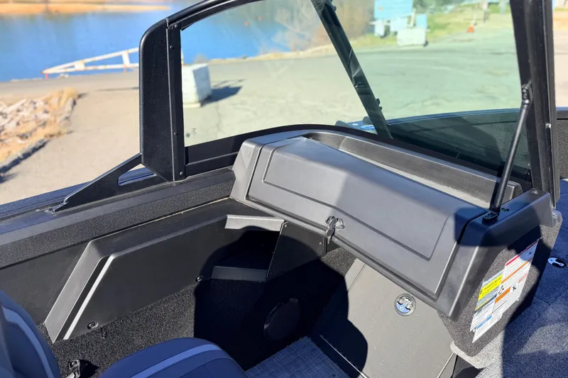 Slide: The Image of 2025 Alumacraft Competitor 185X Sport boat interior with open glove compartment by the water. - 26