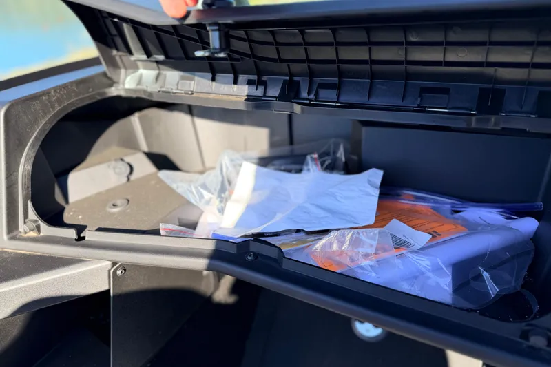 Slide: The Image of Open storage compartment of 2025 Alumacraft Competitor 185X Sport boat with miscellaneous items. - 27