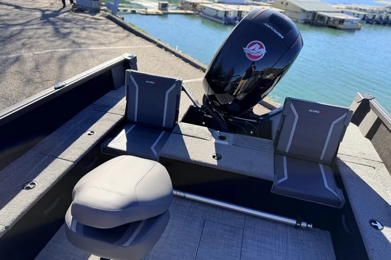 Slide: The Image of 2025 Alumacraft Competitor 185X Sport boat interior with Mercury engine by the water. - 30