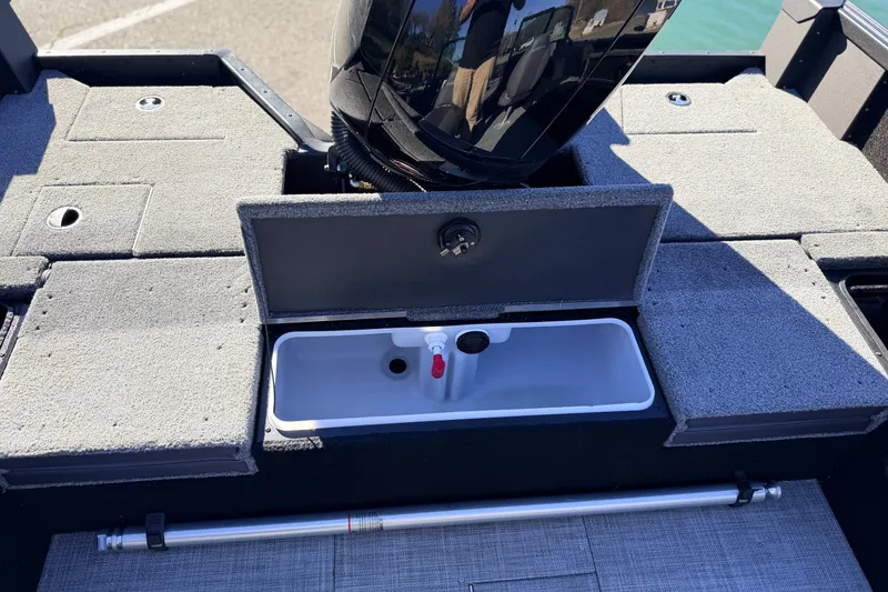 Slide: The Image of 2025 Alumacraft Competitor 185X Sport boat interior with storage compartments and motor. - 33