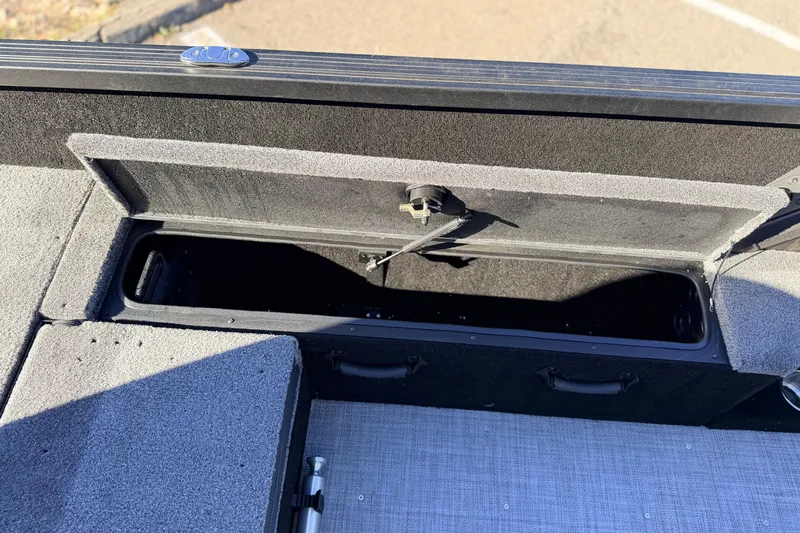 Slide: The Image of 2025 Alumacraft Competitor 185X Sport boat storage compartment, open and empty. - 34