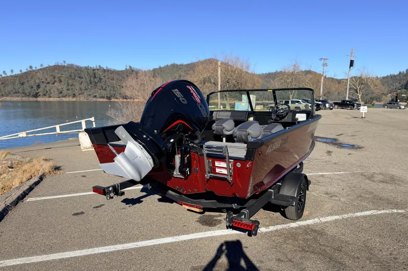 Slide: The Image of 2025 Alumacraft Competitor 185X Sport boat parked near a scenic lake. - 8