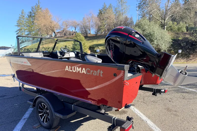Slide: The Image of 2025 Alumacraft Competitor 185X Sport boat on trailer, parked outdoors. - 9