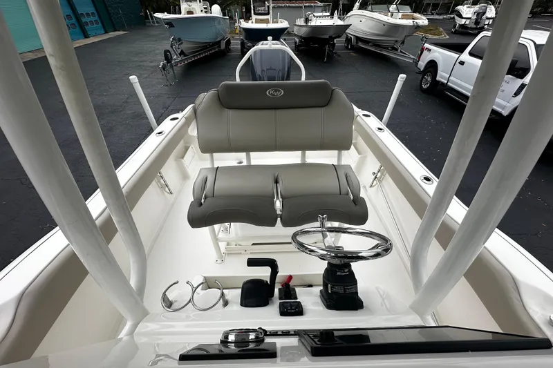 Slide: The Image of 2023 Key West 239 FS boat interior with steering wheel and seating, parked outdoors. - 11
