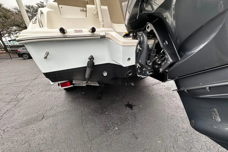 Slide: The Image of 2023 Key West 239 FS boat rear view with outboard motor on pavement. - 4