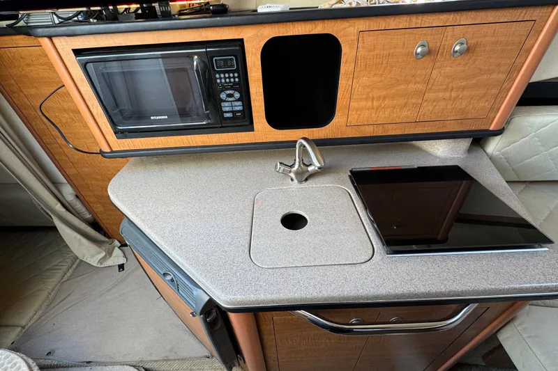 Slide: The Image of 2006 Sea Ray Sundancer 280 galley with microwave, sink, and stove. - 16