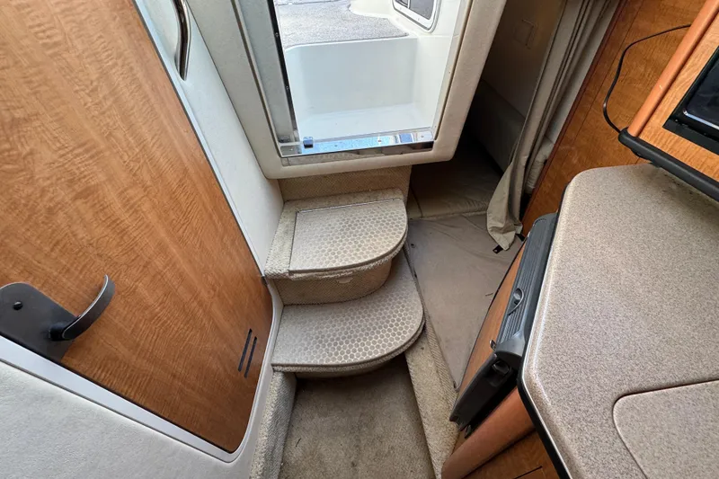 Slide: The Image of Interior view of 2006 Sea Ray Sundancer 280, featuring carpeted steps and wooden cabinetry. - 23