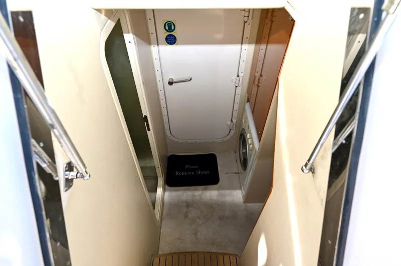 Slide: The Image of Interior view of 2005 Sunseeker 82 Yacht, featuring a narrow passageway and door. - 49