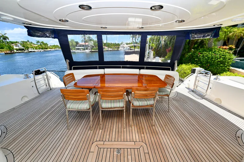 Slide: The Image of Sunseeker 82 Yacht 2005 aft deck with dining table, chairs, and waterfront view. - 8
