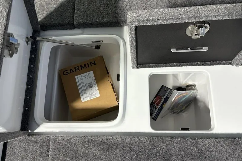 Slide: The Image of Open storage compartments in a 2026 Phoenix 20 XE boat, featuring a Garmin box. - 32