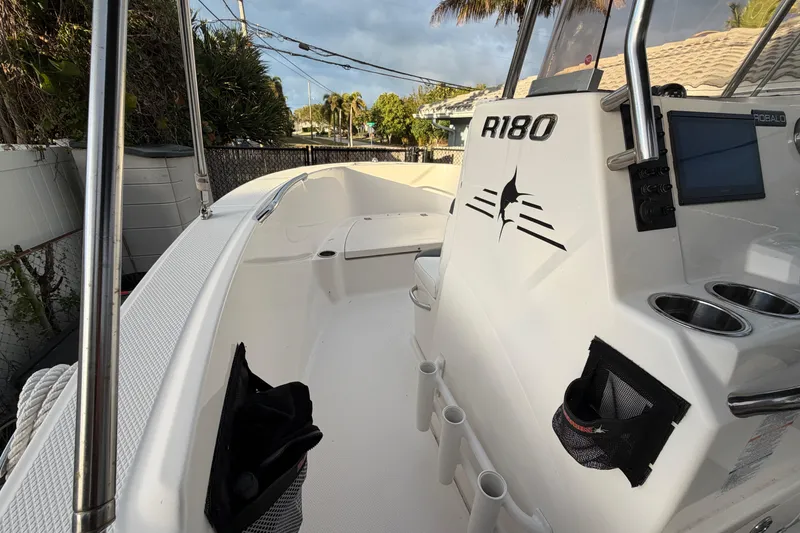 Slide: The Image of 2018 Robalo R180 Center Console boat interior with rod holders and console details. - 16