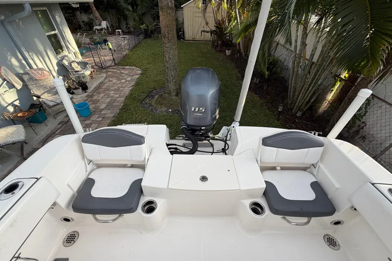 Slide: The Image of 2018 Robalo R180 Center Console boat with Yamaha 115 engine in a backyard setting. - 20