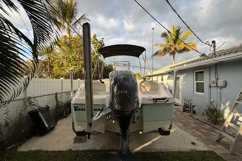 Slide: The Image of 2018 Robalo R180 Center Console boat parked in a tropical backyard setting. - 4