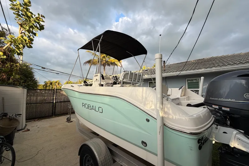 Slide: The Image of 2018 Robalo R180 Center Console boat on trailer, parked outdoors. - 5
