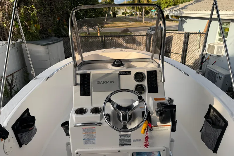 Slide: The Image of 2018 Robalo R180 Center Console boat with Garmin navigation system and steering wheel. - 7