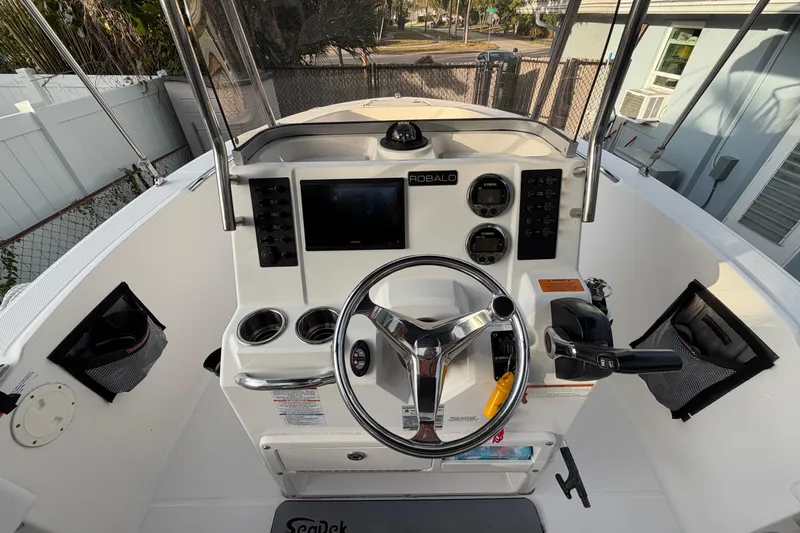 Slide: The Image of 2018 Robalo R180 Center Console boat dashboard with steering wheel and controls. - 9