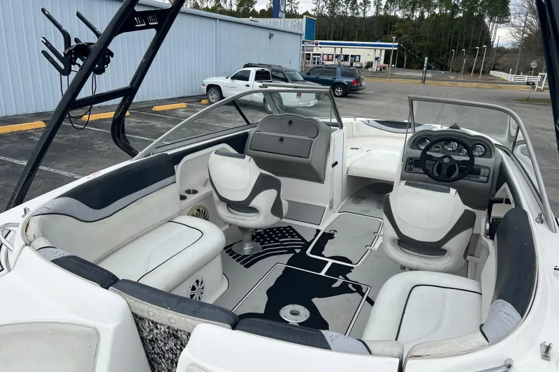 Slide: The Image of 2006 Yamaha Boats SX230 HO interior with seating, steering wheel, and dashboard in a parking lot. - 25