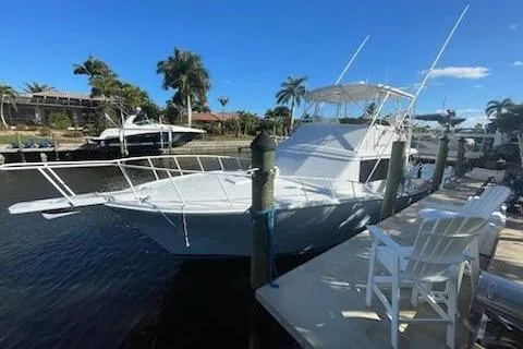 The Image of 1987 Topaz 44 Flybridge yacht docked by palm trees under clear blue sky. - 0