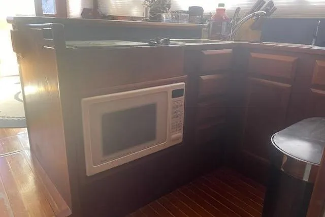 Slide: The Image of 1987 Topaz 44 Flybridge kitchen with built-in microwave and wooden cabinetry. - 3