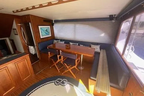 Slide: The Image of Interior of 1987 Topaz 44 Flybridge yacht with dining area and wooden furnishings. - 5