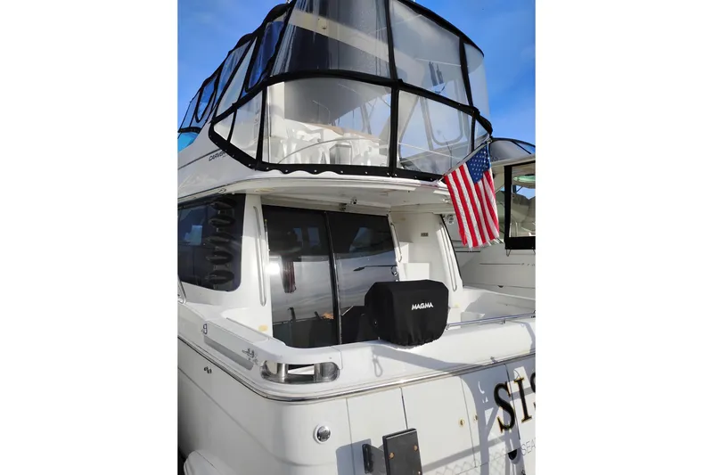 Slide: The Image of 2000 Carver 450 Voyager Pilothouse yacht with American flag and covered grill. - 2