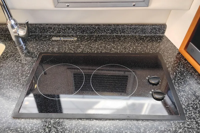 Slide: The Image of Ceramic cooktop in 2000 Carver 450 Voyager Pilothouse kitchen, featuring dual burners and sleek design. - 23