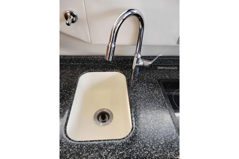 Slide: The Image of Kitchen sink with chrome faucet in 2000 Carver 450 Voyager Pilothouse yacht. - 24