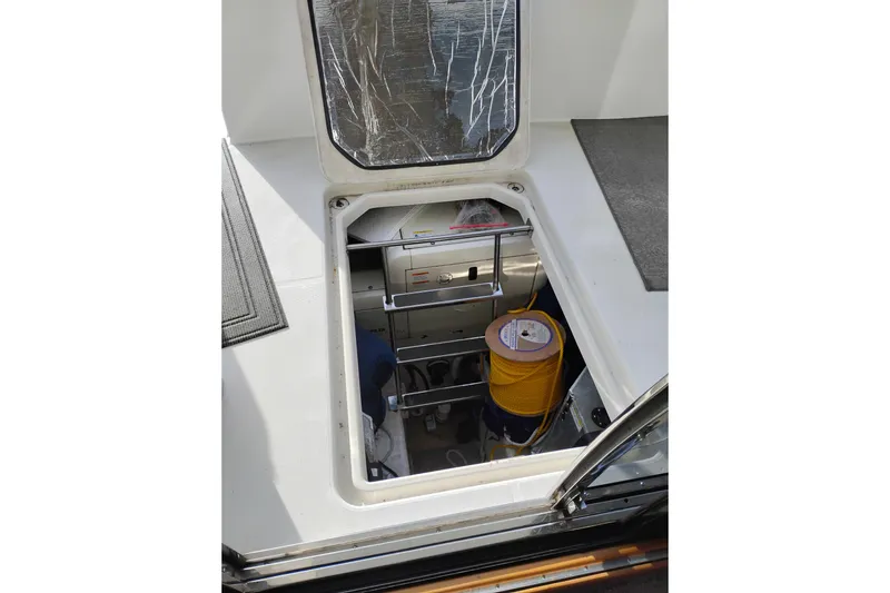 Slide: The Image of Open hatch on 2000 Carver 450 Voyager Pilothouse, revealing storage area with equipment. - 38