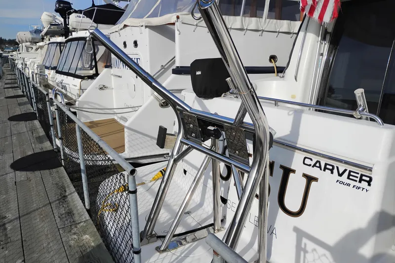 Slide: The Image of 2000 Carver 450 Voyager Pilothouse yacht docked at marina with chrome railings. - 49