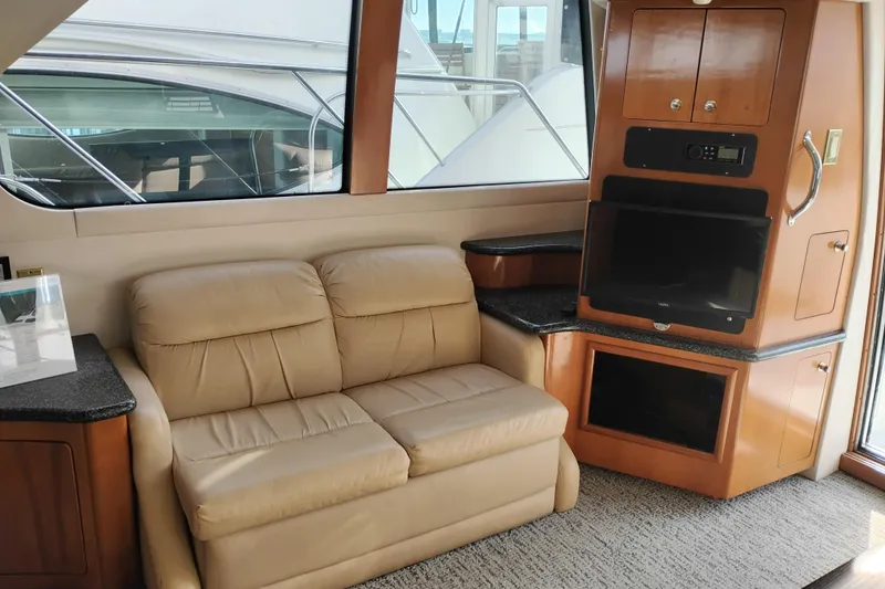 Slide: The Image of Interior of 2000 Carver 450 Voyager Pilothouse with beige sofa and entertainment center. - 7