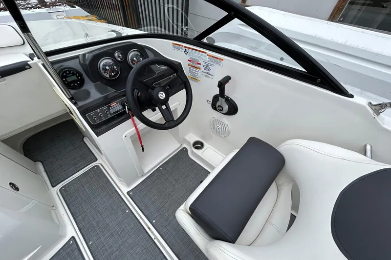 Slide: The Image of 2021 Bayliner VR4 Bowrider I/O cockpit with steering wheel and control panel. - 2