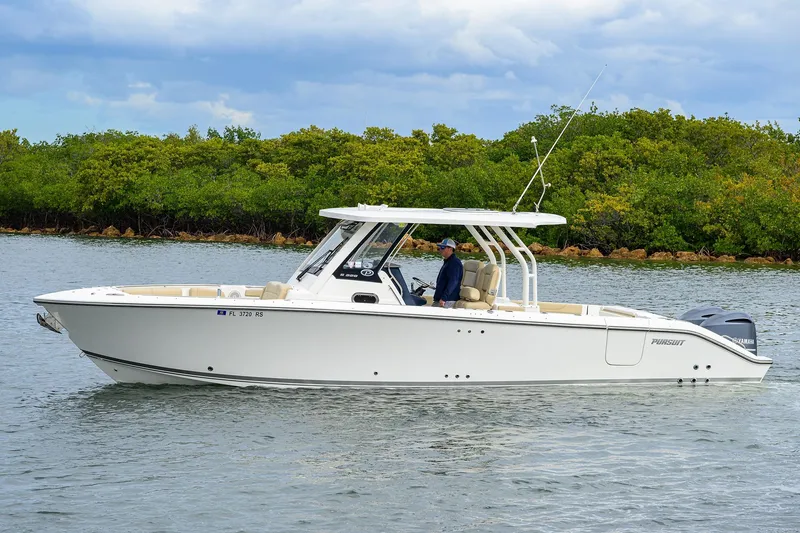 The Image of 2019 Pursuit S 328 Sport boat cruising on calm water near lush greenery. - 0