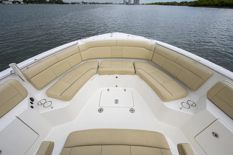 Slide: The Image of 2019 Pursuit S 328 Sport boat with spacious beige seating on calm water. - 14