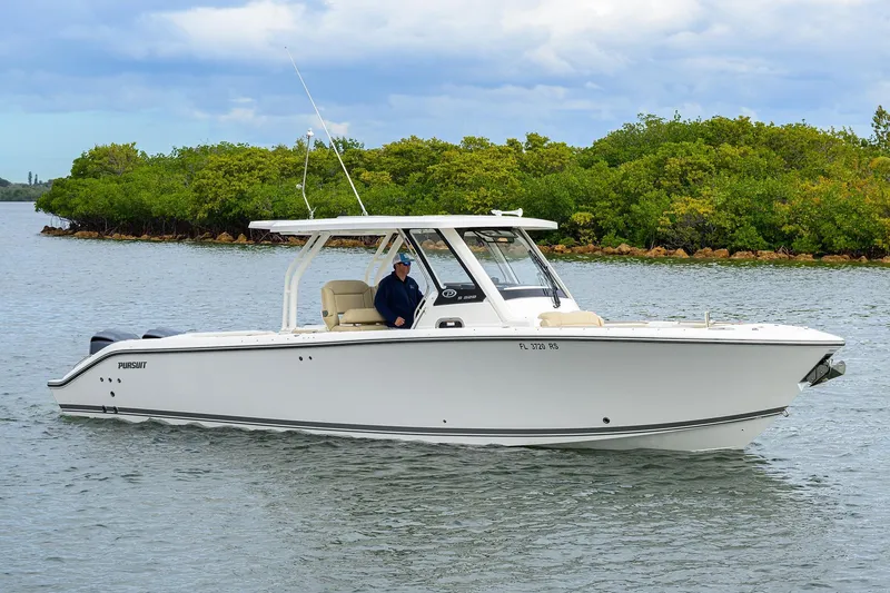 Slide: The Image of 2019 Pursuit S 328 Sport boat cruising on a calm waterway with lush greenery. - 22