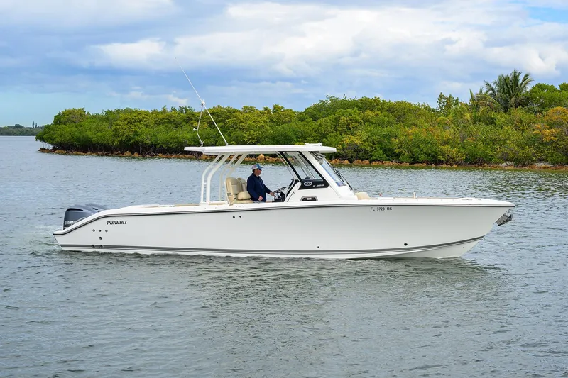 Slide: The Image of 2019 Pursuit S 328 Sport boat cruising on a calm waterway with lush greenery. - 23