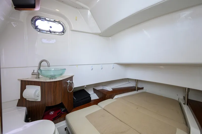 Slide: The Image of 2019 Pursuit S 328 Sport cabin interior with sink, bed, and porthole window. - 27