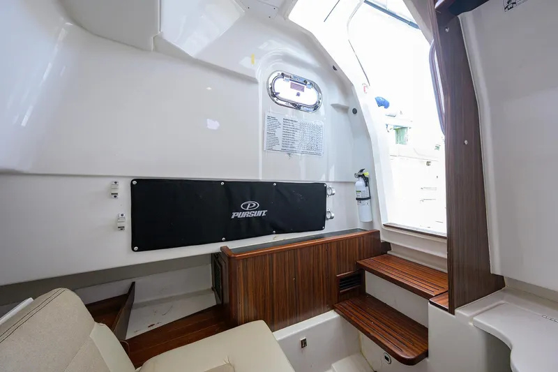 Slide: The Image of Interior of 2019 Pursuit S 328 Sport boat with wooden accents and seating area. - 32